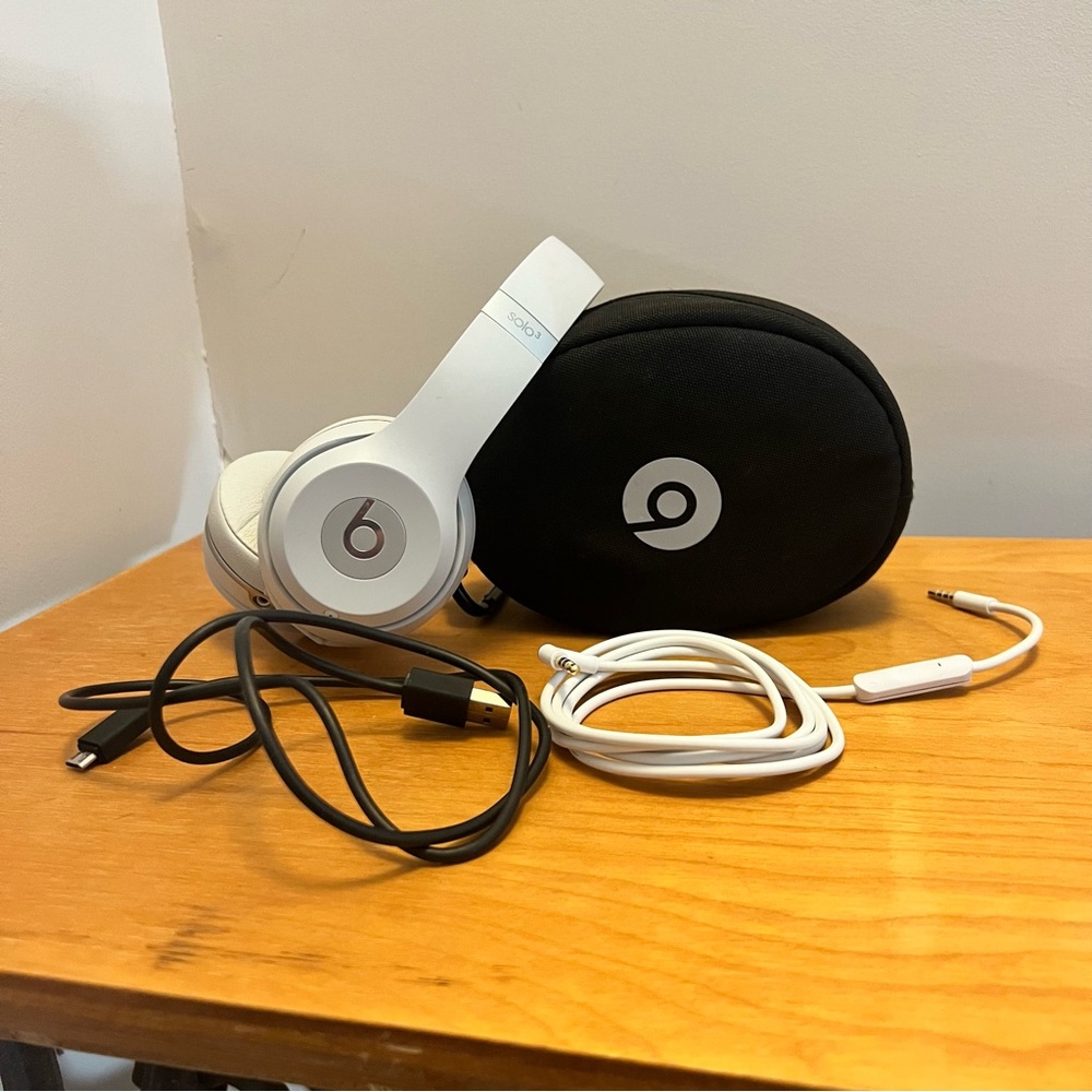 Beats Solo3 wireless on-ear headphones, silver, with carrying case and cables.